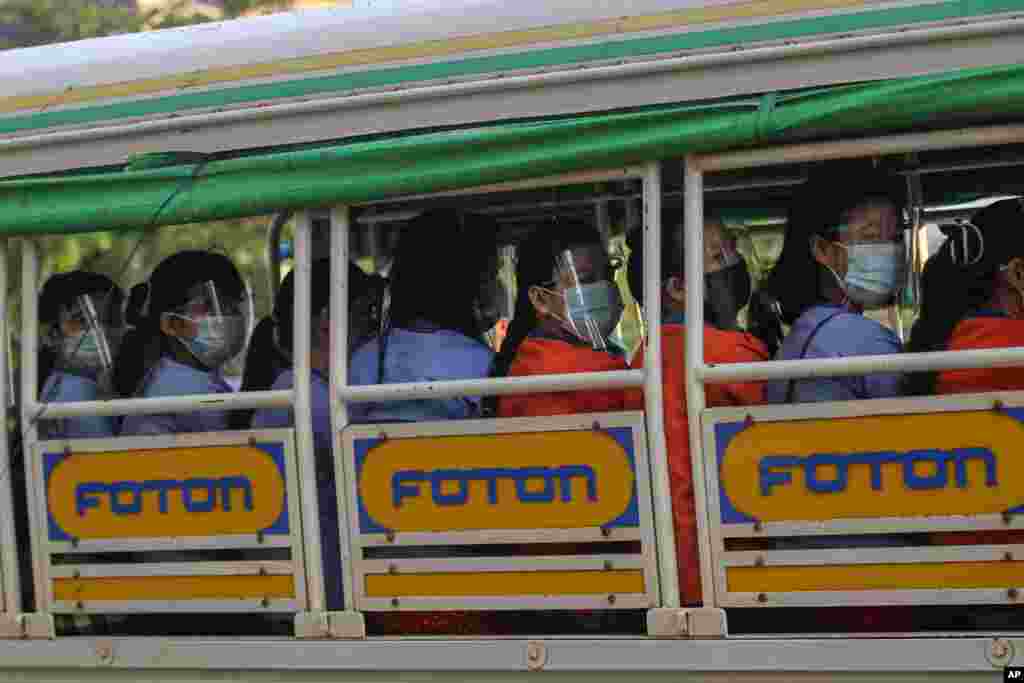 12일 미얀마 양곤에서 트럭에 탄 공장 직원들이 신종 코로나바이러스 감염을 막기 위해 마스크와 안면보호대를 착용하고 있다.