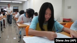 Elementary students are seen studying in a small cram school in hopes of success on their high school entrance exams, Tuesday, July 6, 2010, in Taipei, Taiwan. Taiwanese students spent months preparing for tests that will determine whether they to an elit