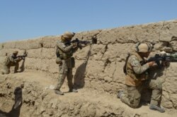 FILE - Afghan security forces take position during a battle with the Taliban in Kunduz province, Afghanistan, Sept. 1, 2019.