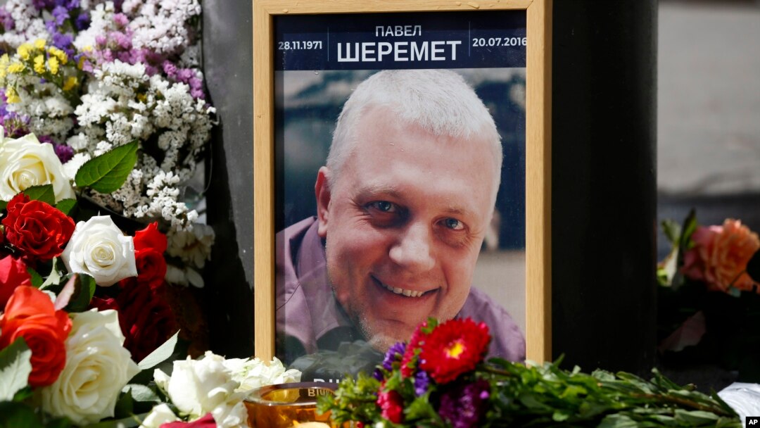 Foto Pavel Sheremet yang dikelilingi bunga dan lilin di tempat kematiannya (20/7). Kiev, Ukraina. (foto: AP Photo/Sergei Chusavkov)