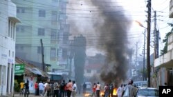 Protesting Muslim youths stand next to burning tires in Mombasa, Kenya after Aboud Rogo, a Muslim cleric facing terror-related charges, was shot dead, Aug. 27, 2012. 