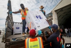 FILE - Boxes of a COVID-19 vaccine provided through the global COVAX initiative are unloaded at the airport in Mogadishu, Somalia, March 15, 2021.