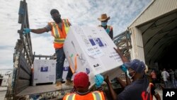 FILE - Boxes of a COVID-19 vaccine provided through the global COVAX initiative are unloaded at the airport in Mogadishu, Somalia, March 15, 2021.