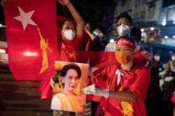 A supporter of National League for Democracy holds a picture of Myanmar State Counselor Aung San Suu Kyi as she waits for results outside the party headquarters after the general election in Yangon, Myanmar, November 8, 2020. REUTERS/Shwe Paw Mya Tin