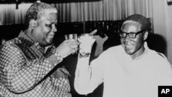 UMnu. Joshua Nkomo loMnu. Robert Mugabe balobelana isivumelwano sokukhumisana umlothat ngomnyaka ka1987.