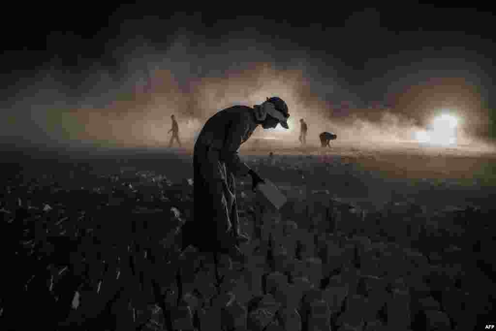 A laborer carries a stone block at the &amp;quot;White Mountain&amp;quot; limestone extraction quarry site near Egypt&amp;#39;s southern city of Minya, some 265 kilometers south of the capital Cairo.