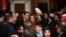 Syrian President Bashar al-Assad, center left, and his wife, Asma al-Assad, center right, pose for a picture with a Syrian man at a Christmas choral presentation at the Lady of Damascus Catholic Church, in Damascus, Dec. 18, 2015. 