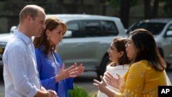 Prince William and his wife Kate speaks to teachers during their visit to a school in Islamabad, Pakistan, Oct. 15, 2019.