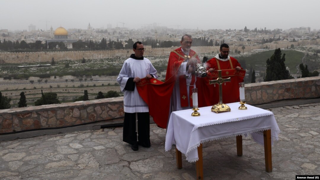 Uskup Agung Perbattista Pizzaballa dari Latin Patriarchate Yerusalem dan pemimpin Katolik Roma lainnya menggelar misa di Gunung Zaitun yang menghadap tembok-tembok Kota Tua Yerusalem. Tidak ada prosesi Minggu Palem seperti sebelumnya karena wabah virus corona, 5 April 2020.
