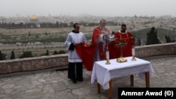 Uskup Agung Perbattista Pizzaballa dari Latin Patriarchate Yerusalem dan pemimpin Katolik Roma lainnya menggelar misa di Gunung Zaitun yang menghadap tembok-tembok Kota Tua Yerusalem. Tidak ada prosesi Minggu Palem seperti sebelumnya karena wabah virus corona, 5 April 2020.