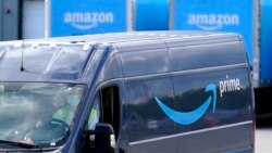 FILE: An Amazon Prime logo appears on the side of a delivery van as it departs an Amazon Warehouse location in Dedham, Mass. on Oct. 1, 2020