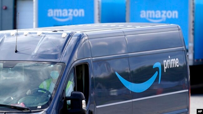 FILE: An Amazon Prime logo appears on the side of a delivery van as it departs an Amazon Warehouse location in Dedham, Mass. on Oct. 1, 2020