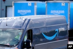 FILE: Logo Amazon Prime pada mobil van pengiriman barang, saat berangkat dari lokasi Gudang Amazon di Dedham, Massachussetts, 1 Oktober 2020