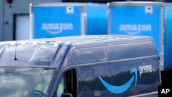 Sebuah mobil pengantar dengan logo Amazon prime terpasang di badannya berjalan keluar dari gudang milik perusahaan ritel daring Amazon di Dedham, Massachusetts, pada 1 Oktober 2020. (Foto: AP/Steven Senne)