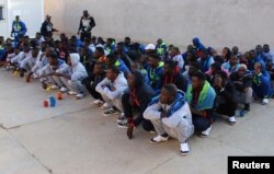 FILE - Migrants wait before being deported by Libyan authorities, in Misrata, Libya, Feb. 19, 2018.