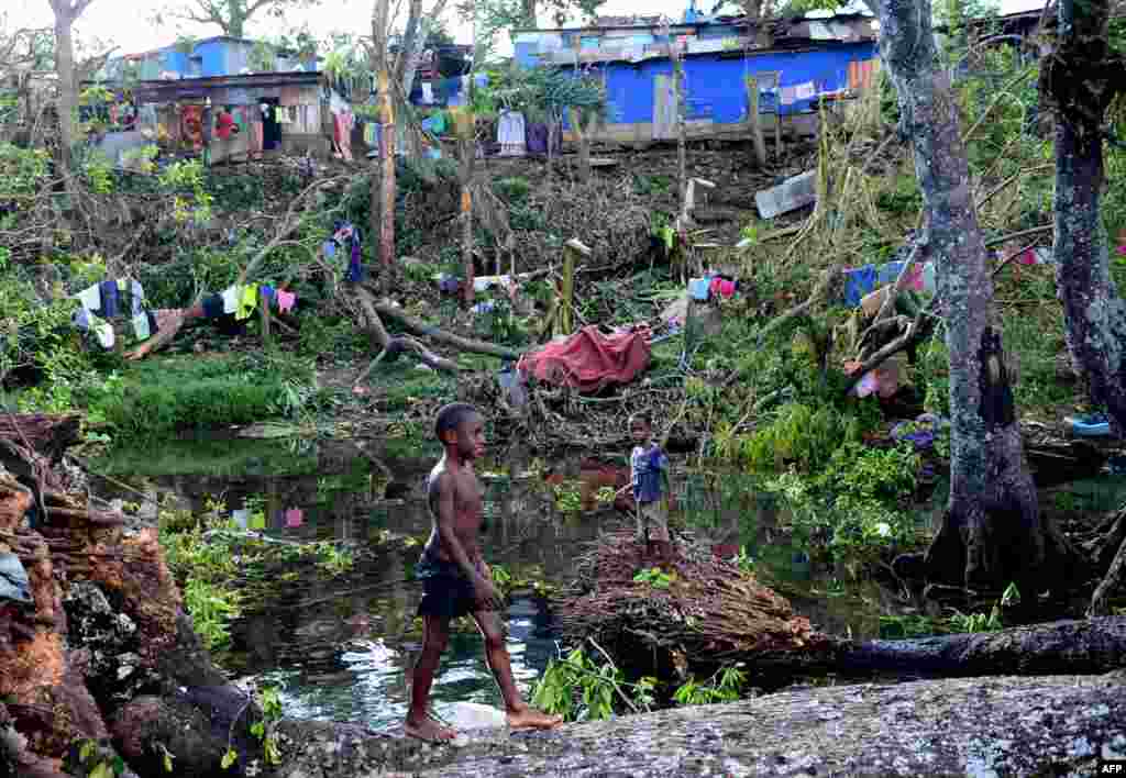 Children play in water amongst the debris of fallen trees just outside Vanuatu's capital, Port Vila, after Cyclone Pam ripped through the island nation, March 17, 2015..