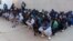 FILE - Migrants wait before being deported by Libyan authorities, in Misrata, Libya, Feb. 19, 2018.