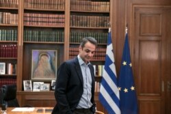 FILE - Greece's Prime Minister Kyriakos Mitsotakis waits for a meeting with Klaus Regling, Managing Director of EMS (European Stability Mechanism), in his office, in Athens, March 7, 2020.