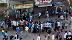 Indians line up without maintaining physical distance to buy liquor outside one of the liquor shops which reopened Monday after six weeks lockdown on the outskirts of Mumbai, India, May 4, 2020. 
