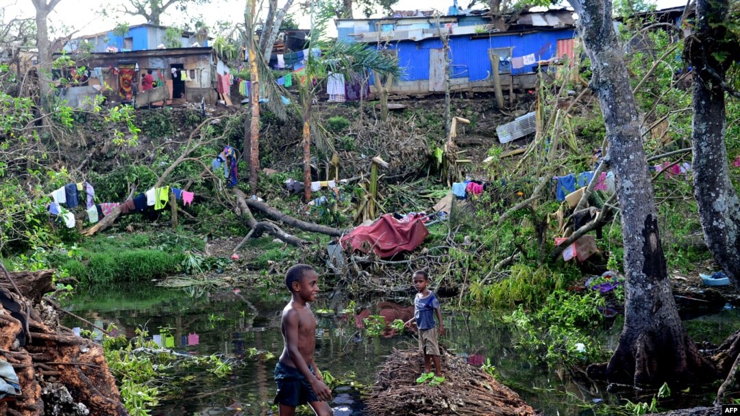 Anak-anak bermain air di antara puing-puing pohon tumbang di luar ibukota Vanuatu, Port Vila, pasca hantaman Topan Pam yang melanda negara kepulauan tersebut, 17 Maret 2015. (Foto: dok).