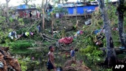 Anak-anak bermain air di antara puing-puing pohon tumbang di luar ibukota Vanuatu, Port Vila, pasca hantaman Topan Pam yang melanda negara kepulauan tersebut, 17 Maret 2015. (Foto: dok).