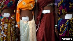 Women who underwent surgery at a government mass sterilization camp pose for pictures inside hospital, Bilaspur district in the eastern Indian state of Chhattisgarh, India, Nov. 14, 2014.