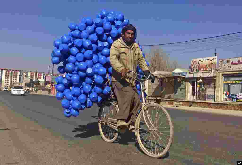 An Afghan man carries plastic cans for sale in Kabul, Afghanistan.
