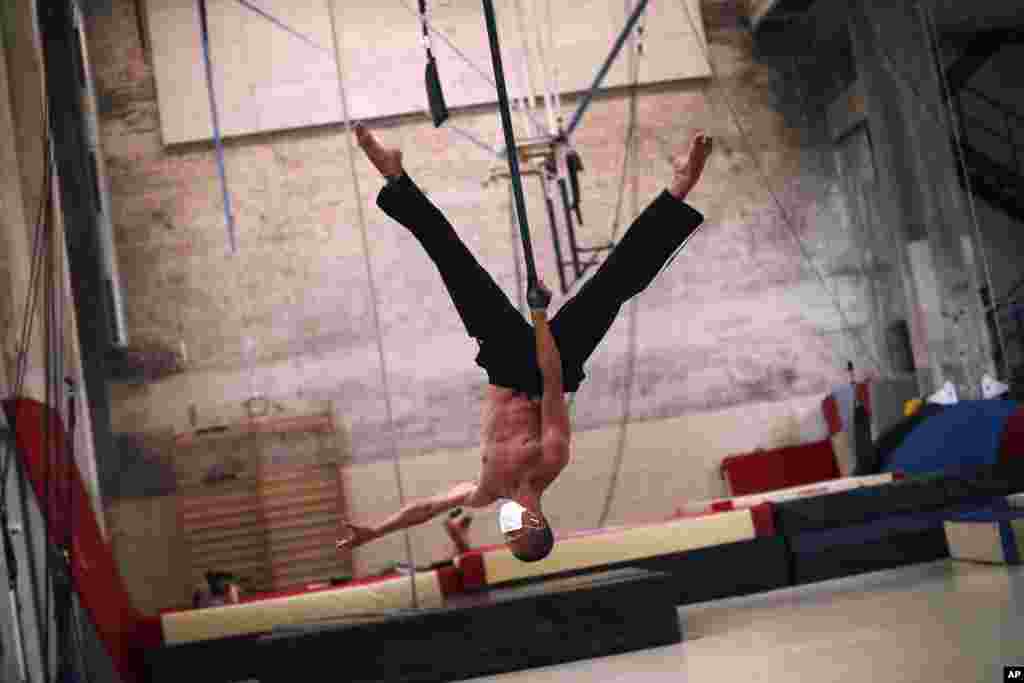 Chinese student Ting Kuan Zhao, wearing a face mask to fight against the spread of the coronavirus, works out at the Superior School of Circus (ESAC) in Brussels, Belgium.