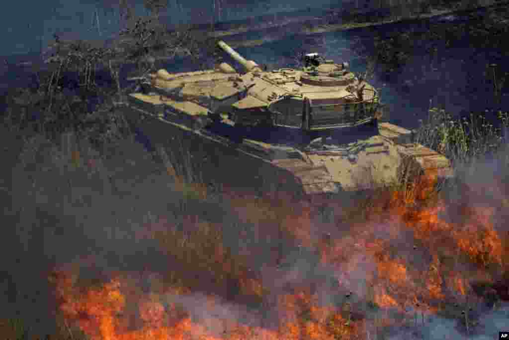 An old tank is surrounded by fire following explosions of mortar shells from Syria on the Israeli controlled Golan Heights. Three mortar shells exploded on the Israeli side of the border fence with Syria on the Golan Heights. No casualties or damage were reported from the incident.