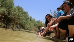 FILE - In this July 6, 2015, photo, Jordanian Christians pour water over themselves at what they believe to be Jesus' baptismal area on the eastern bank of the Jordan River in South Shuna, Jordan.