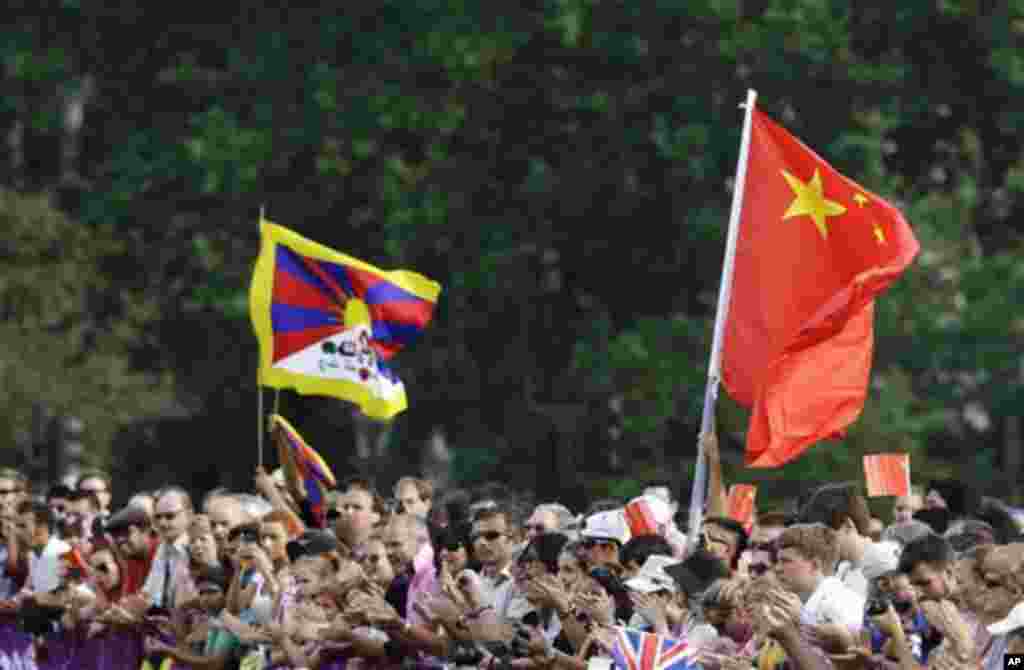 A Tibetan flag, left, and Chinese flag are held by spectators during the women&#39;s 20-kilometer race walk, at the 2012 Summer Olympics, Saturday, Aug. 11, 2012, in London.