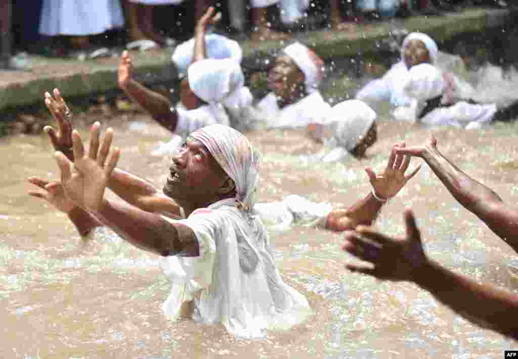 Haitian voodoo followers bathe in a sacred pool during a voodoo ceremony in Souvenance, a suburb of Gonaives, 171 km north of Port-au-Prince.