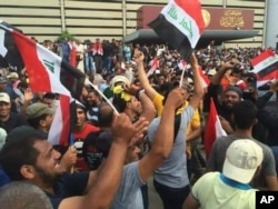 伊拉克什叶派教士穆克塔达.阿萨德的支持者在巴格达绿区内的伊拉克议会外挥舞伊拉克旗帜 (2016年4月30日)