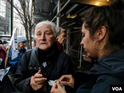 Barbara Moore, 81, tends to her wounds after a scuffle broke out between activists and police outside New York’s immigration court, following news that Ravi Ragbir, a well-known immigrant-rights activist, had been detained. (R. Taylor/VOA)