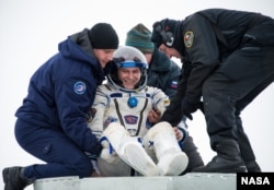 FILE - Expedition 38 Flight Engineer Sergey Ryazanskiy of the Russian Federal Space Agency, Roscosmos, is helped out of the Soyuz Capsule.