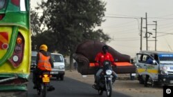 Muendesha boda boda akipita kwenye barabara, wakati wa msongamano wa magari jioni jijini Nairobi, Septemba 26, 2018. Picha ya AFP.