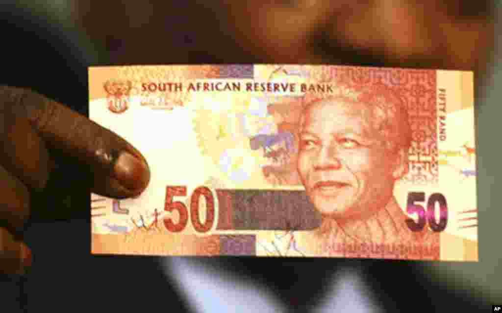 South Africa's President Jacob Zuma holds up a banknote bearing the face of former president Nelson Mandela in Pretoria February 11, 2012.