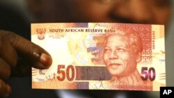 South Africa's President Jacob Zuma holds up a banknote bearing the face of former president Nelson Mandela in Pretoria February 11, 2012.