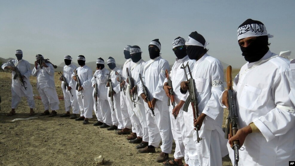 FILE - Taliban suicide bombers stand guard during a gathering of a breakaway Taliban faction, in the border area of Zabul province, Afghanistan. 