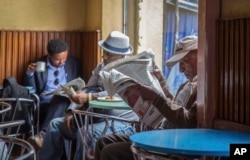 FILE - In this Oct. 10, 2016, photo, Ethiopian men read newspapers and drink coffee at a cafe during a declared state of emergency in Addis Ababa, Ethiopia. Since 2015 there have been wide-ranging internet shutdowns.