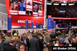 Delegates mingle before the start of Monday night's program on the floor of the Republican National Convention being held at Quicken Loans Arena in Cleveland, July 18, 2016.