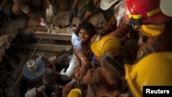 FILE - Rescue workers rescue a garment worker from the rubble of the collapsed Rana Plaza building, in Savar, 30 km (19 miles) outside Dhaka, Bangladesh, April 27, 2013. 