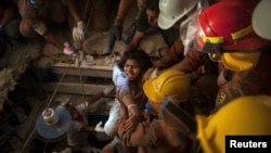 FILE - Rescue workers pull a garment worker from the rubble of a collapsed building outside of Dhaka April 27, 2013.