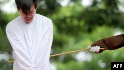 FILE - One of two Indonesian men is publicly caned for having sex, in a first for the Muslim-majority country where there are concerns over mounting hostility towards the small gay community, in Banda Aceh, May 23, 2017.