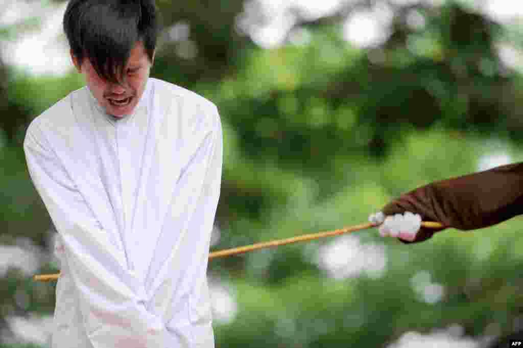 One of two men is publicly caned for having sex, in a first for the Muslim-majority country, where there are concerns over mounting hostility toward the small gay community, in Banda Aceh, Indonesia. The pair, aged 20 and 23, were found guilty of having broken sharia rules in conservative Aceh province -- the only part of Indonesia that implements Islamic law -- and they each were sentenced to 85 strokes of the cane.