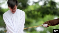 Salah satu dari dua orang Indonesia yang dicambuk di depan umum di Banda Aceh, karena berhubungan seks sesama jenis, 23 Mei 2017.