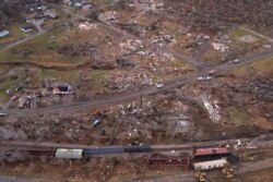 Kereta tampak tergelincir di tengah kerusakan dan puing-puing akibat hantaman tornado di beberapa negara bagian AS di Earlington, Kentucky, AS, 11 Desember 2021. (Foto: REUTERS/Cheney Orr)