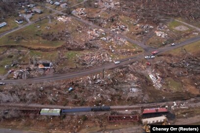 Kereta tampak tergelincir di tengah kerusakan dan puing-puing akibat hantaman tornado di beberapa negara bagian AS di Earlington, Kentucky, AS, 11 Desember 2021. (Foto: REUTERS/Cheney Orr)