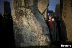فردی در کنار ستون سنگی استون‌هنج در ایمزبری، بریتانیا - آرشیو