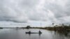 Hombres indígenas miskitos usan un bote para cruzar una carretera inundada por el río Wawa Boom debido a las fuertes lluvias causadas por el huracán Iota a su paso por la costa caribeña en Bilwi en 2020.